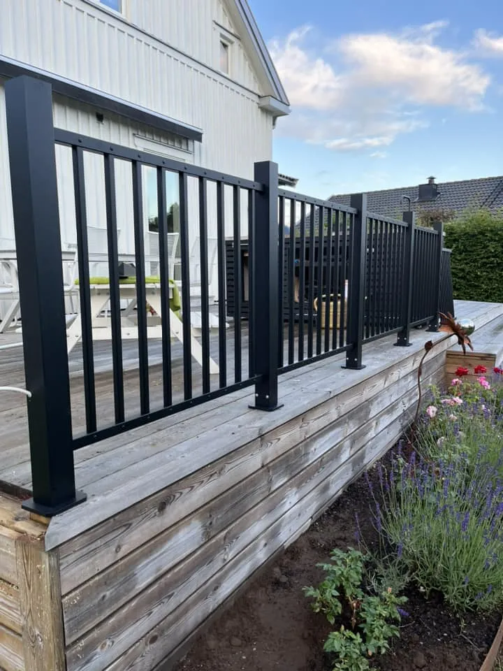 Svart málmhandrið með standandi rimlum.